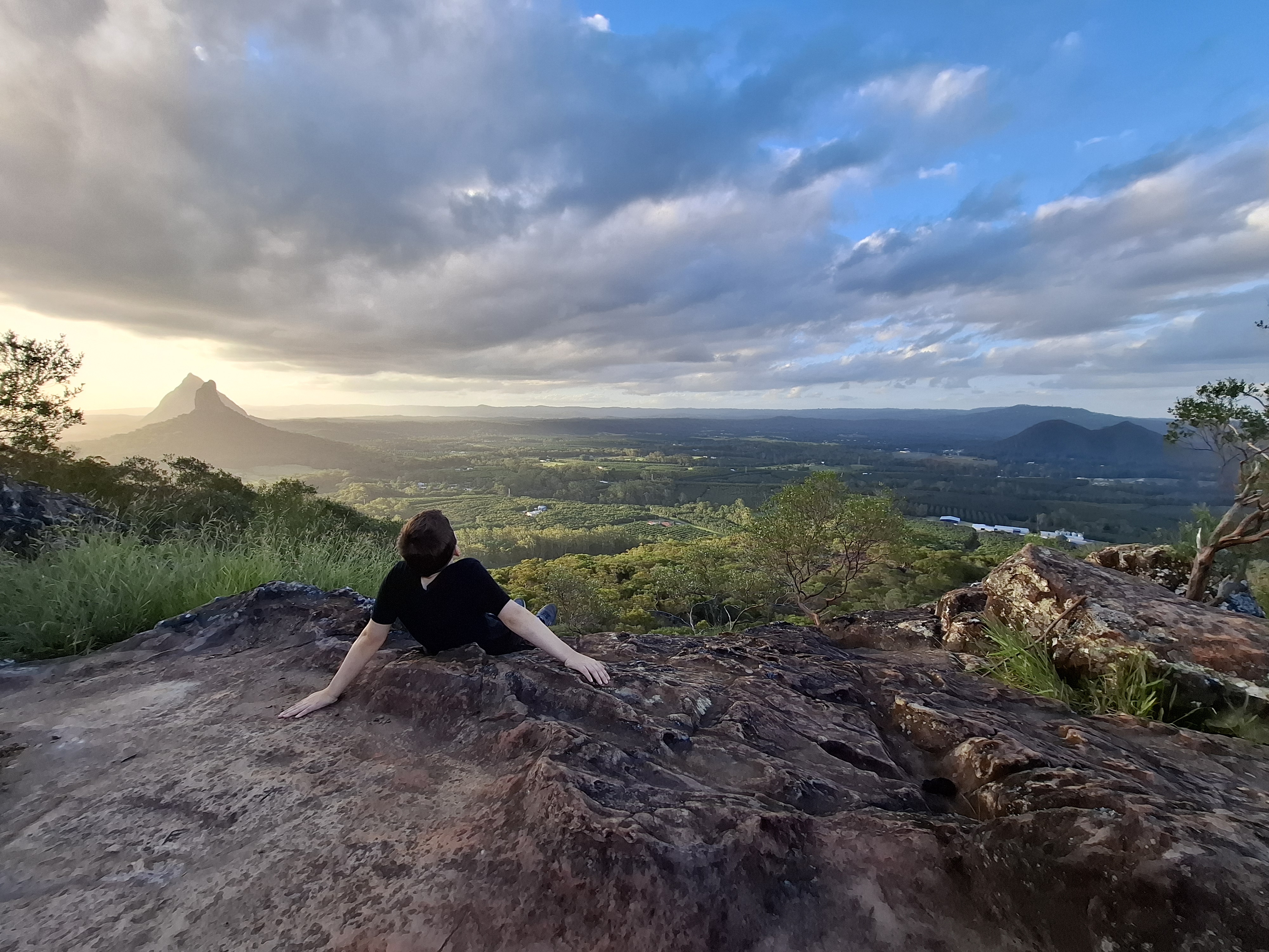 Child sitting on rocks on top of Ngungun