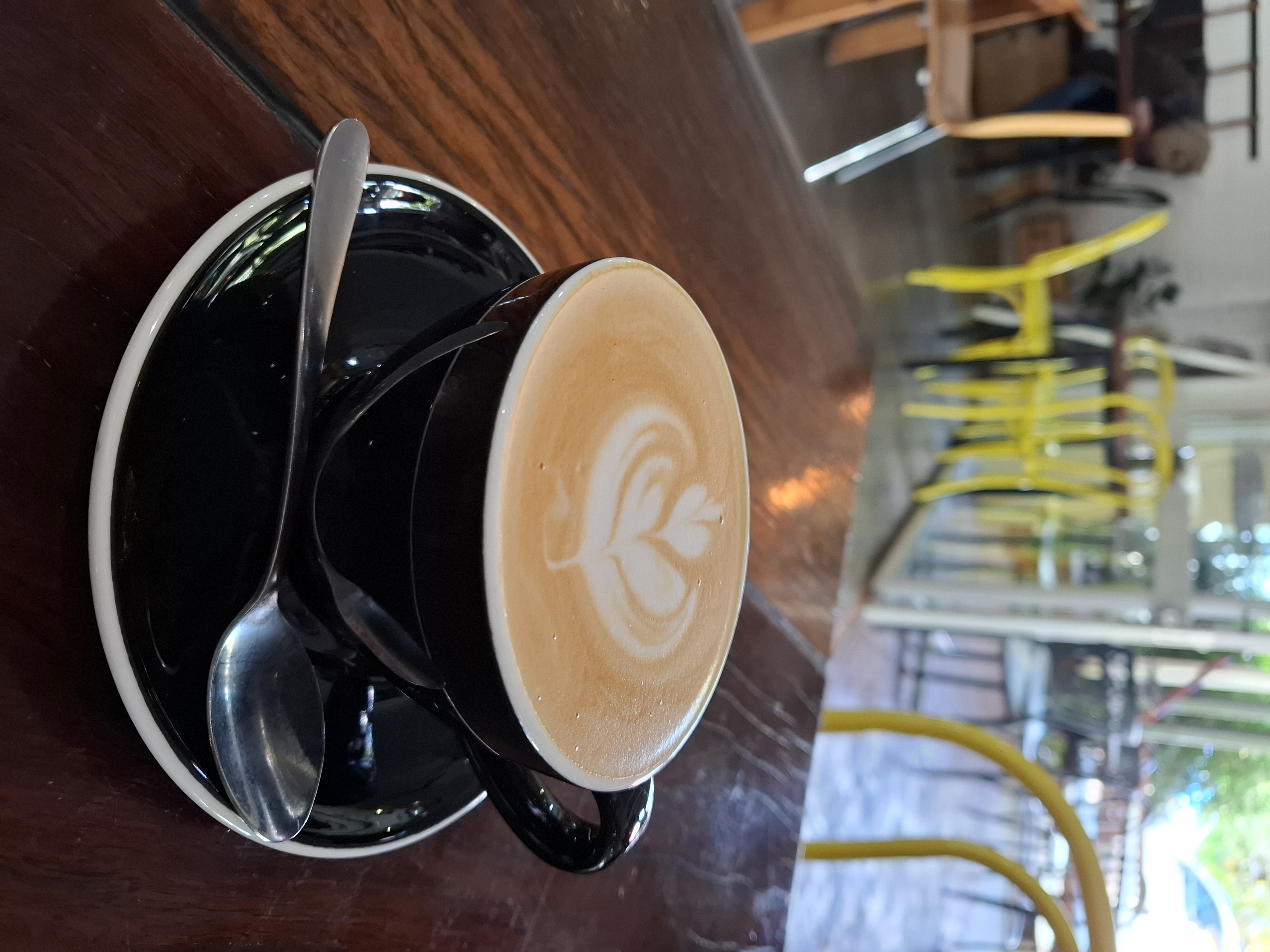 black coffee mug and sauce with coffee art on flat white black coffee mug and sauce with coffee art on flat white