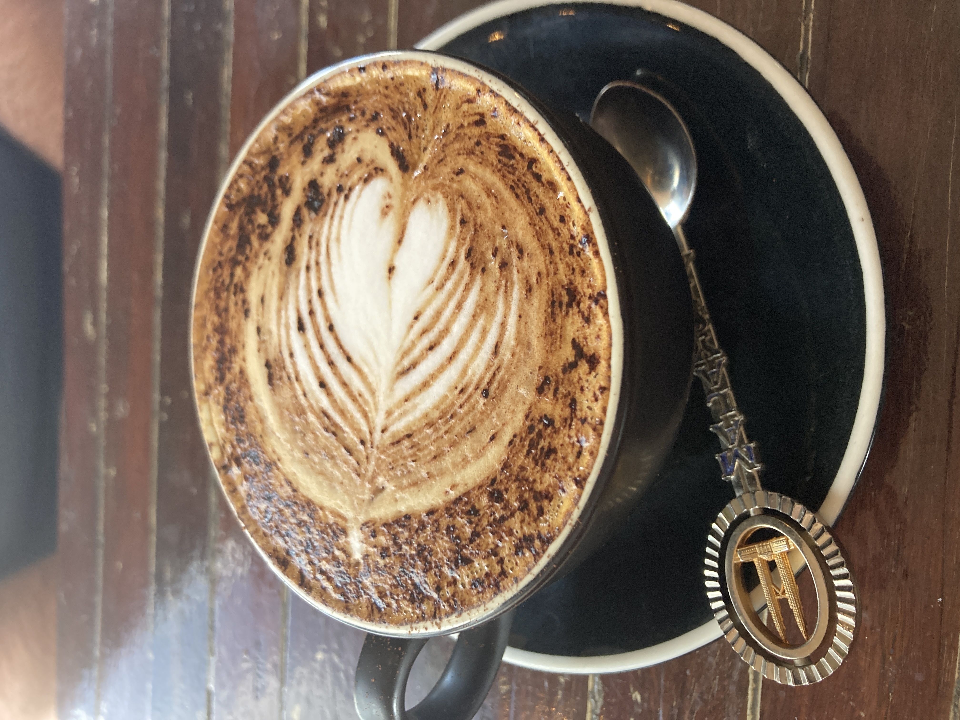 flat white cup of coffee with cute spoon and artwork flat white cup of coffee with cute spoon and artwork