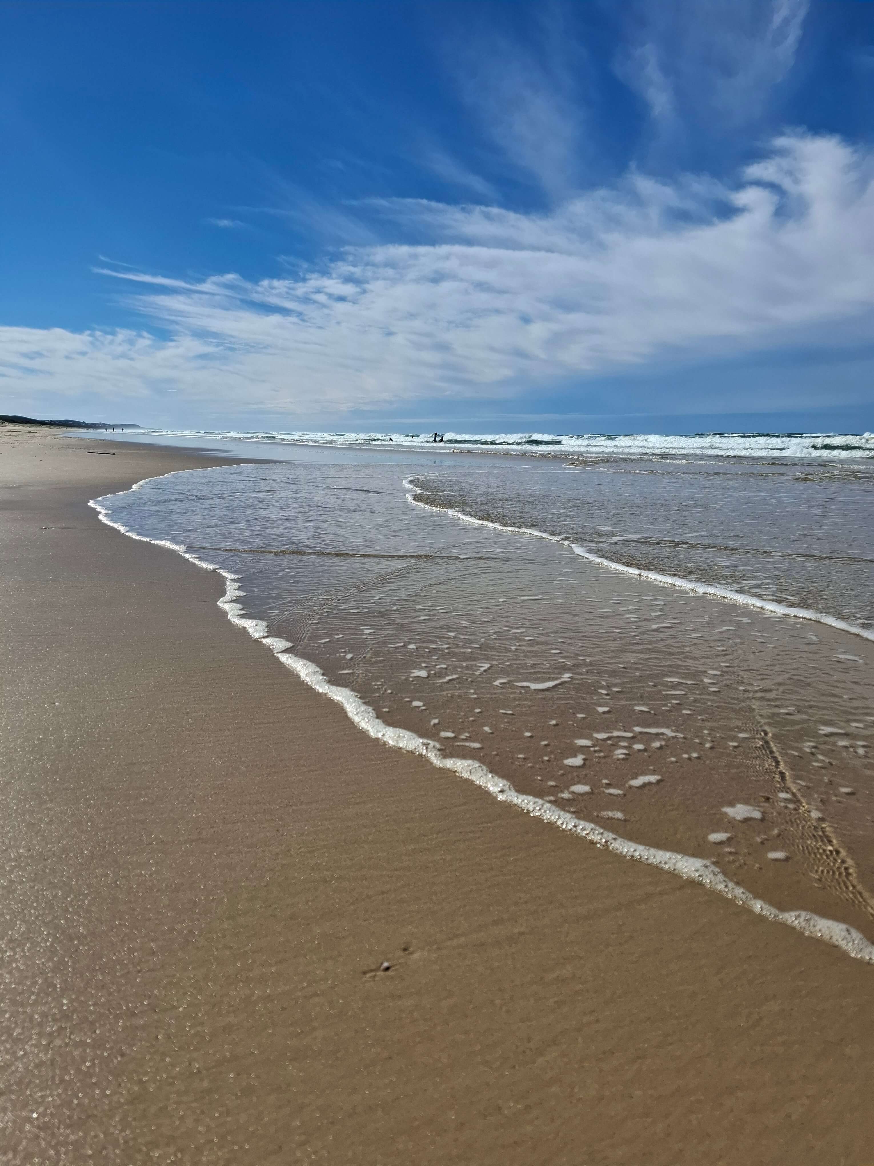 sunshine and sea calm day at the beach with a blue sky overhead sunshine and sea calm day at the beach with a blue sky overhead